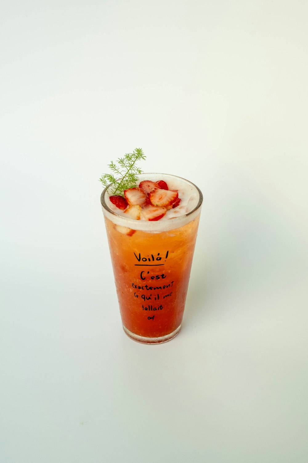 Iced strawberry fruit tea topped with fresh strawberries