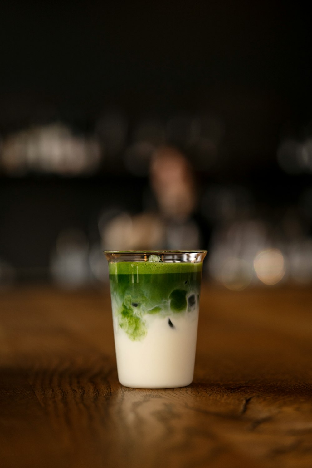 Iced matcha latte layered over milk in a glass