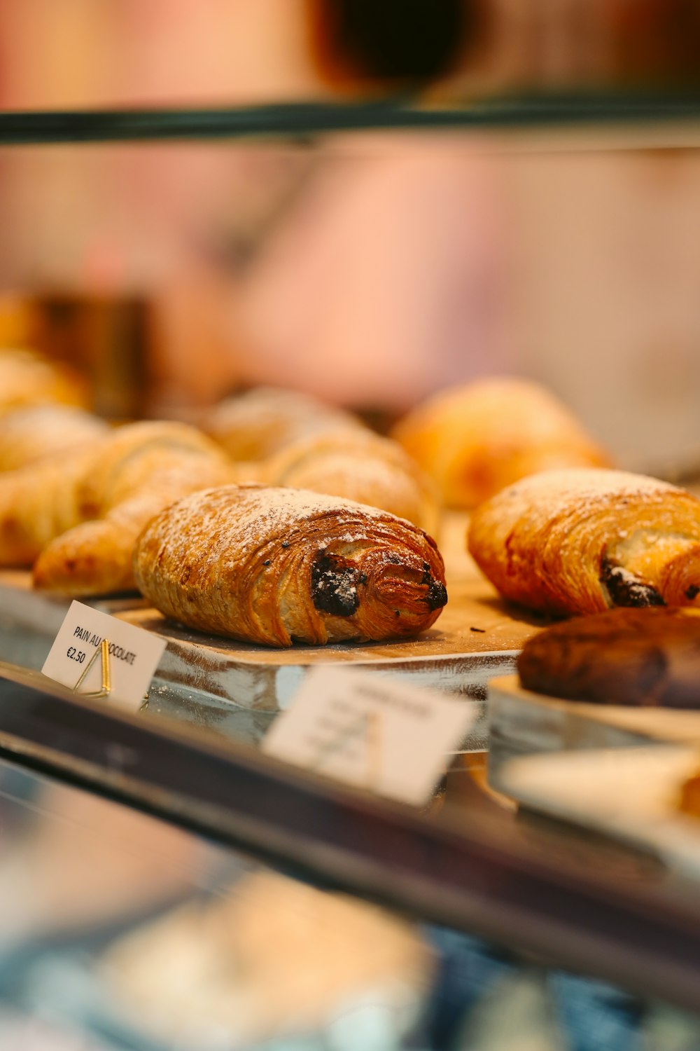Croissants and chocolate pastries in a bakery display case